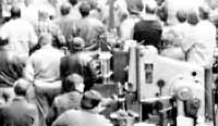 Arbeiter eines Industriebetriebes bei einer Massenzusammenkunft in der Werkhalle