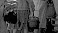 Frauen mit Körben und Taschen stehen vor einem Geschäft an